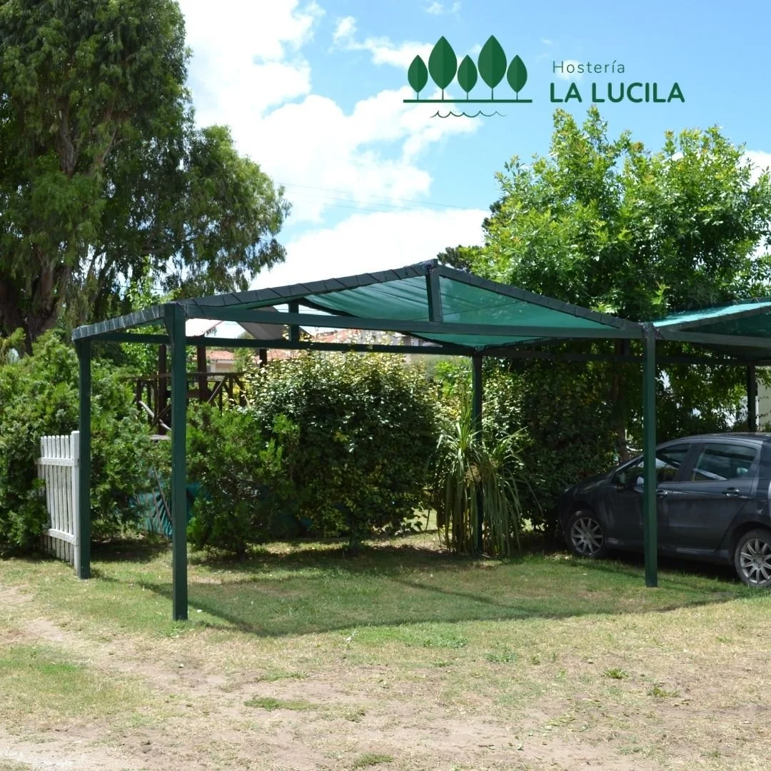 Mesas bajo un sector de sombra en el parque de la hostería
