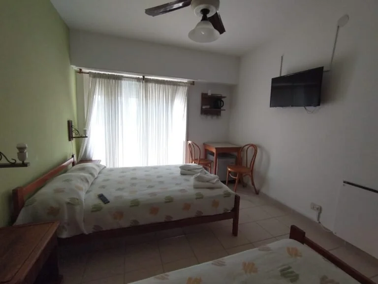 Interior de la Triple con Balcón, con sus camas y la puerta hacia el exterior